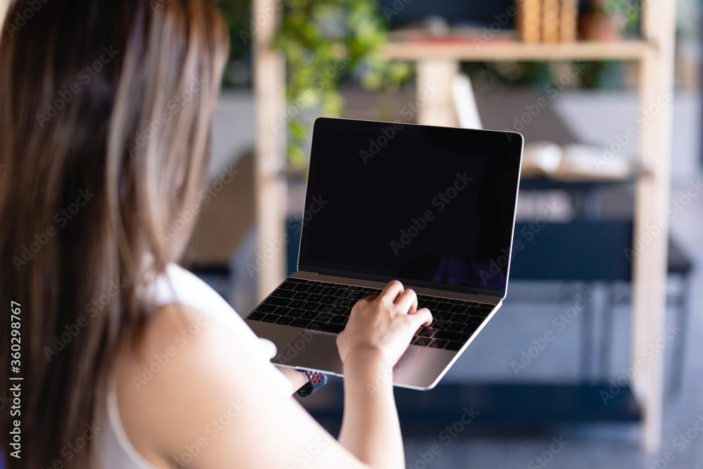 Focus on a laptop holding by a woman Focus on a laptop holding by a woman