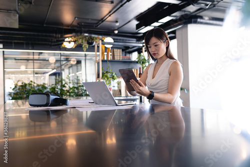 Asian business woman using digital tablet in office
