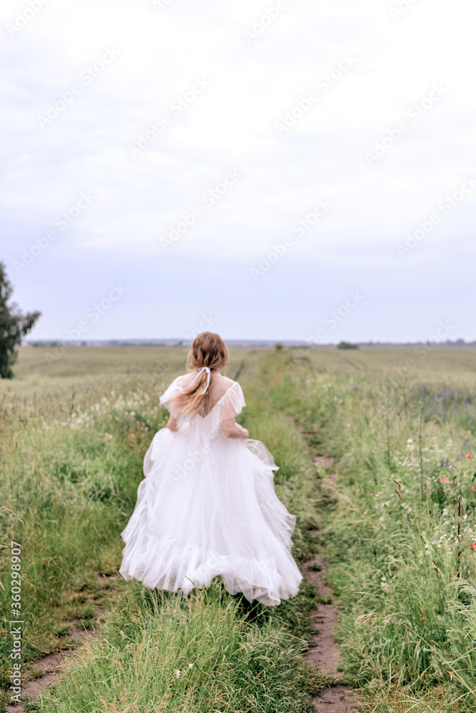 Lady (bride) in white dress running into the field