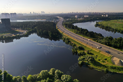 panoramic view of expressway across the river taken from a drone at dawn