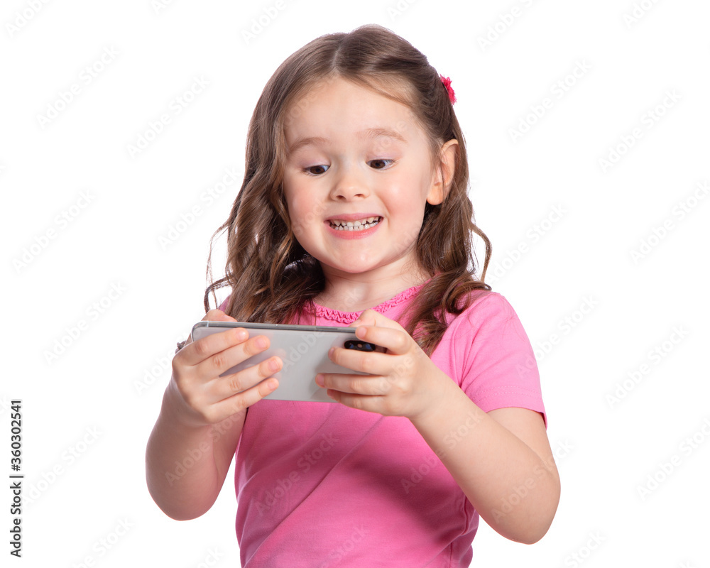 Beautiful European girl 4 years old playing games on the phone, enthusiastic, happy, surprised. Portrait of a 4-year-old child with a gadget on a white background. Internet technologies. Beautiful European girl 4 years old playing games on the phone, enthusiastic, happy, surprised. Portrait of a 4-year-old child with a gadget on a white background. Internet technologies.