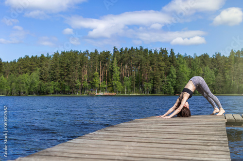 Woman practicing yoga and do exercise. fitness lifestyle at the outdoors nature background. Sunny day on lake