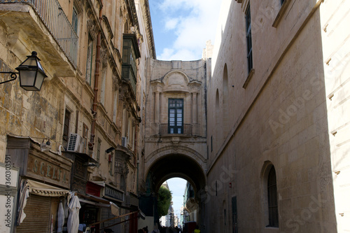 Fototapeta Naklejka Na Ścianę i Meble -  VALLETTA, MALTA - DEC 31st, 2019: Typical narrow cozy street in Valletta, Malta. Old architecture. Traditional maltese architecture