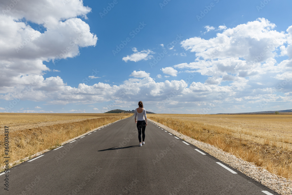 Young woman jumping on the road on nowhere Young woman jumping on the road on nowhere