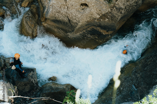 People with wetsuits
and helmet canyoning in a wild river with a lot of water flow photo