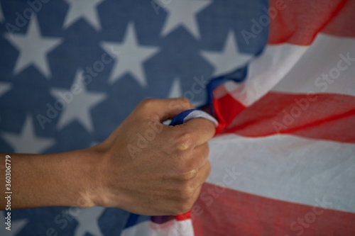 Close-up of dark-skinned female hand clutching usa flag