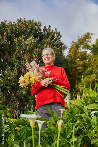 Retired Woman Holding Freshcut Flowers in her Garden photo