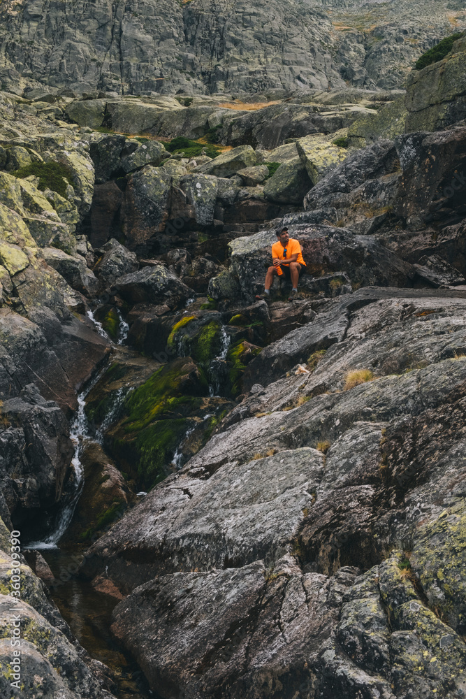A young man sits back and relax while drinking water, Sierra de Gredos A young man sits back and relax while drinking water, Sierra de Gredos
