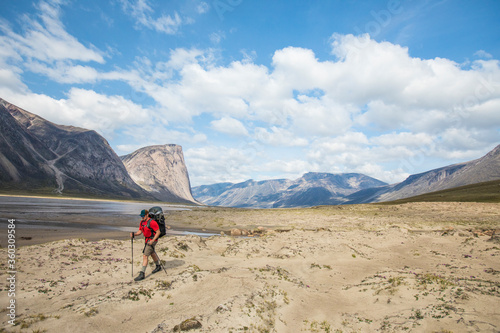 Man hiking next to the Owl River in Akshayak Pass