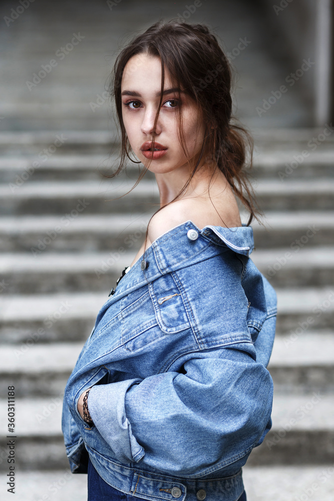 stylish millennial girl with beautiful brown eyes in a denim jacket stylish millennial girl with beautiful brown eyes in a denim jacket