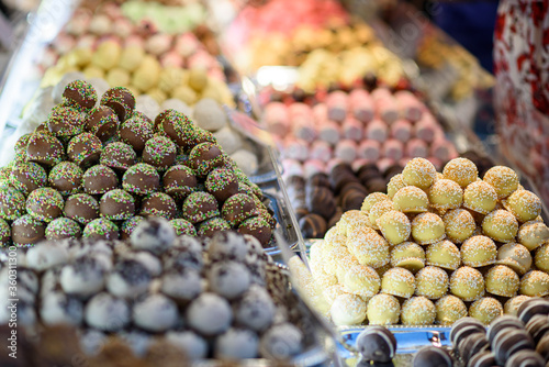Traditional marzipan candies of different colors and flavors displayed for sale on a market. Selective focus. photo