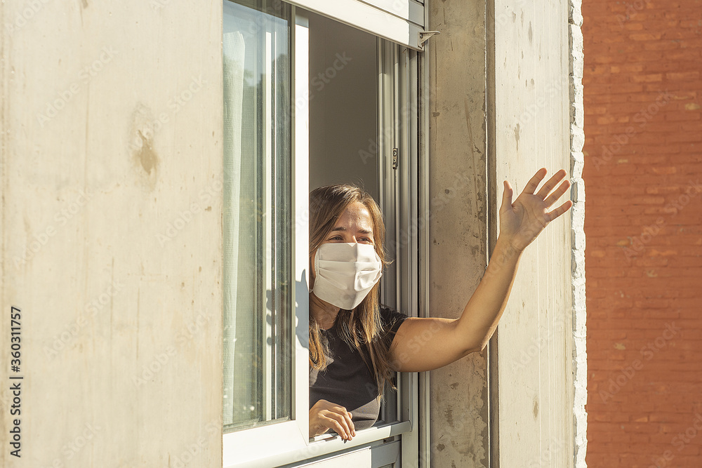 Woman in the windows during quarantine greeting a neighbor Woman in the windows during quarantine greeting a neighbor