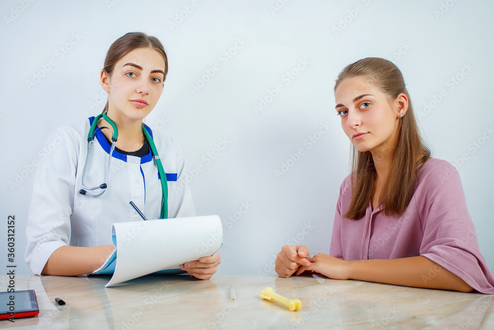 Doctor and patient talking while sitting at the desk in hospital office. Medicine and health care concept. Concept of covid 19 pandemic. Doctor and patient talking while sitting at the desk in hospital office. Medicine and health care concept. Concept of covid 19 pandemic.