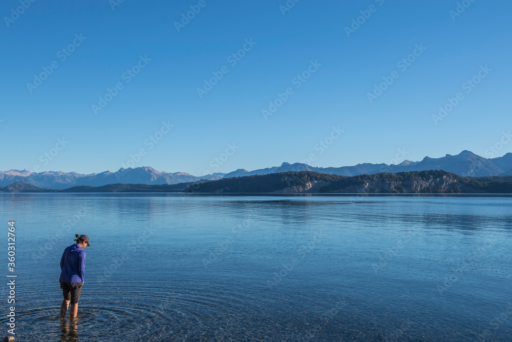 Woman trying the water at Nahuel Huapi Lake in Patagonia Woman trying the water at Nahuel Huapi Lake in Patagonia