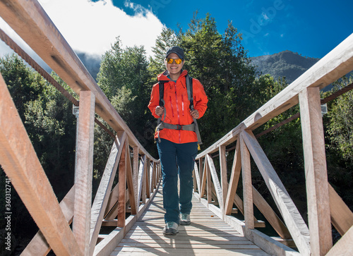 Woman crossing wooden bridge at Caleta Gonzalo in Chile photo