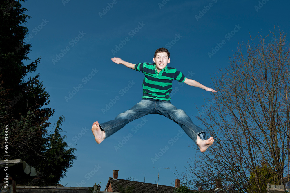 boy jumping on trampoline in Woking - England boy jumping on trampoline in Woking - England