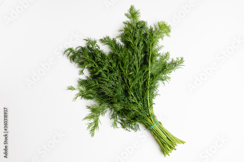 .A bunch of fresh wholesome dill on a white salted background. Fresh seasoning for cooking.