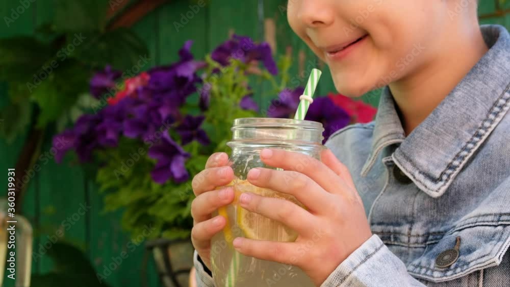 Child drinks fresh homemade lemonade outdoor. Child drinks fresh homemade lemonade outdoor.
