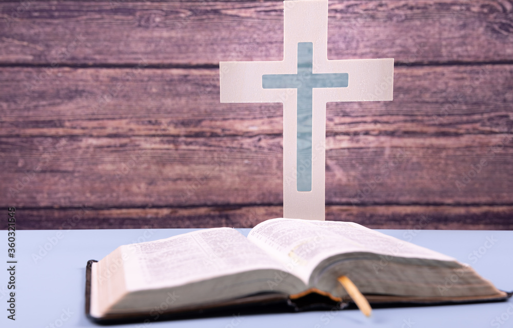 Open Bible and wooden cross on a blue table. Copy space. Church concept Open Bible and wooden cross on a blue table. Copy space. Church concept