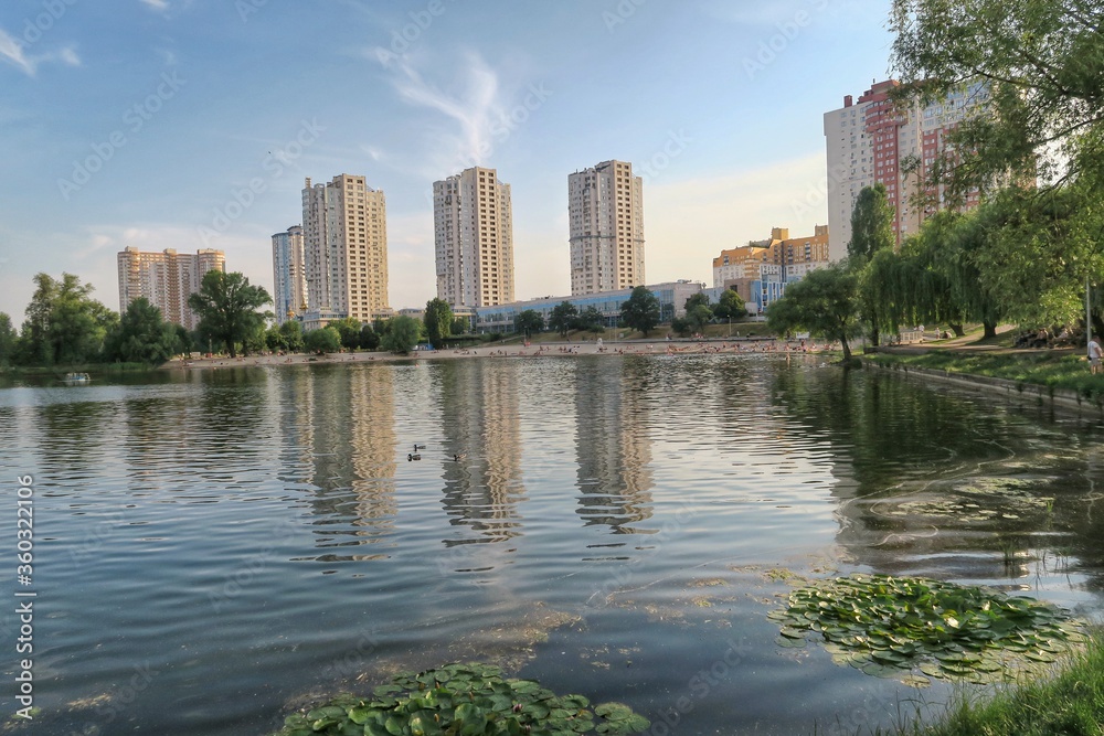Fototapeta premium Kyiv/Kiev skyline at the peaceful river. Soviet looking buildings, river reflection of the buildings. Kyiv Ukraine.