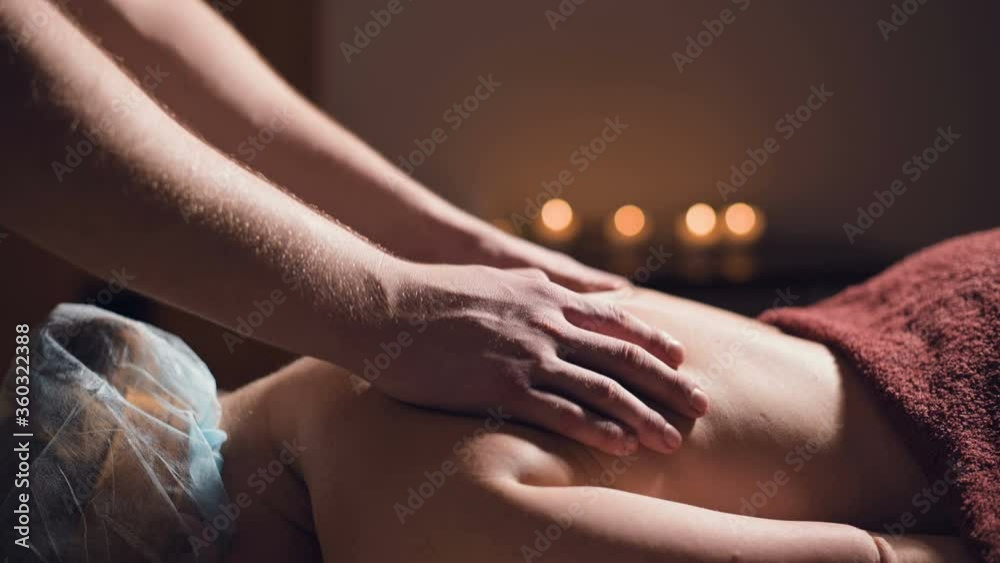 custom made wallpaper toronto digitalClose-up Young male massage therapist does back massage to a woman with a tattoo in a massage room with dim lights on the background of candles. Low key premium massage concept