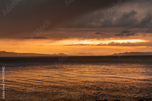 Beautiful landscape. Bright golden sunset with dramatics clouds over the lake after rain. © Inga Av