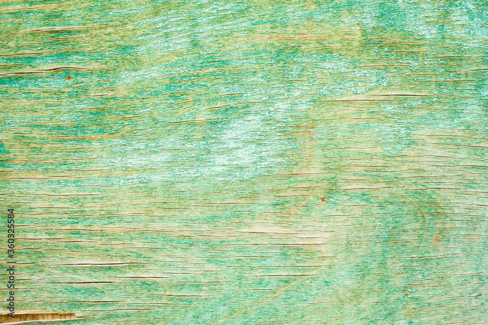 Old green shabby and cracked wooden surface with peeling paint texture background.