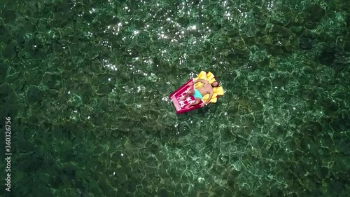 A boy bathes in the sea in a rocky area with a float in summer. High quality FullHD footage
