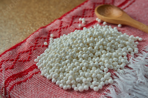 Perlas de tapioca blanca sobre mantel de cocina rojo photo