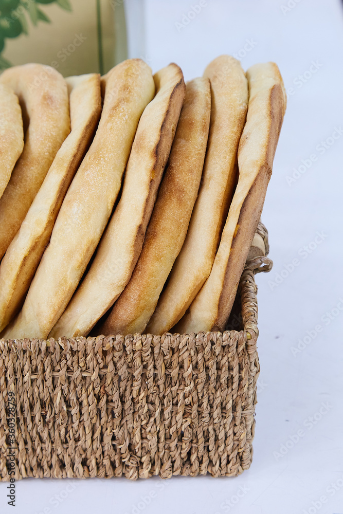 Fresh round pita bread in a wicker basket. Round pita bread with a hole
