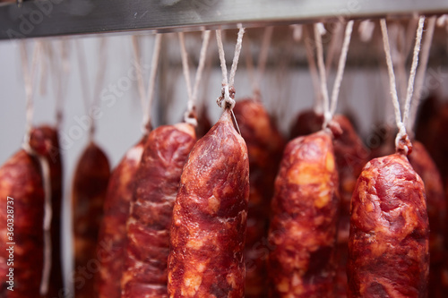 Factory for the production of meat products, cured sausages. Traditional spicy sausage hanging to dry, covered with fungus. Concept of handmade meat products. Delicacy. 