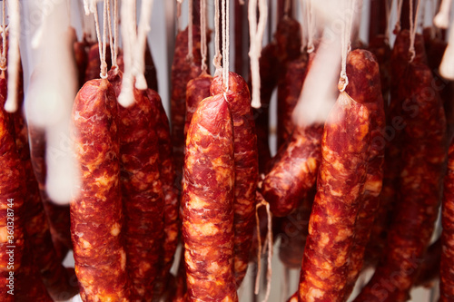 Factory for the production of meat products, cured sausages. Traditional spicy sausage hanging to dry, covered with fungus. Concept of handmade meat products. Delicacy. 