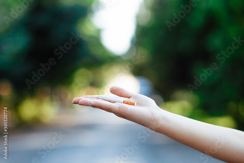 Woman with a cigarette in her hand. Close. Place for text. Smoking cessation concept. Female hand holding a cigarette.
