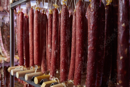 Factory for the production of meat products, cured sausages. Traditional spicy sausage hanging to dry, covered with fungus. Concept of handmade meat products. Delicacy