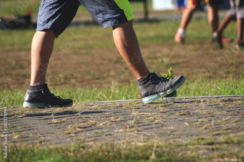 A man wearing sports shoes while walking in the park