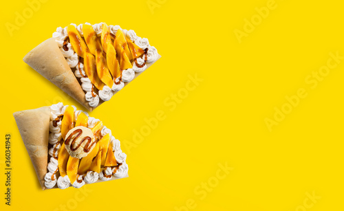 Photography TOP VIEW OF CREPE OR FINE PANCAKE MANGO FLAVOR WITH CREAM ICE CREAM AND CARAMEL