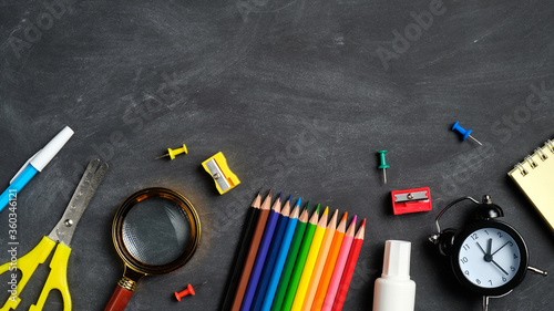 Flat lay school supplies on a blackboard background. Top view, overhead. Back to school concept.