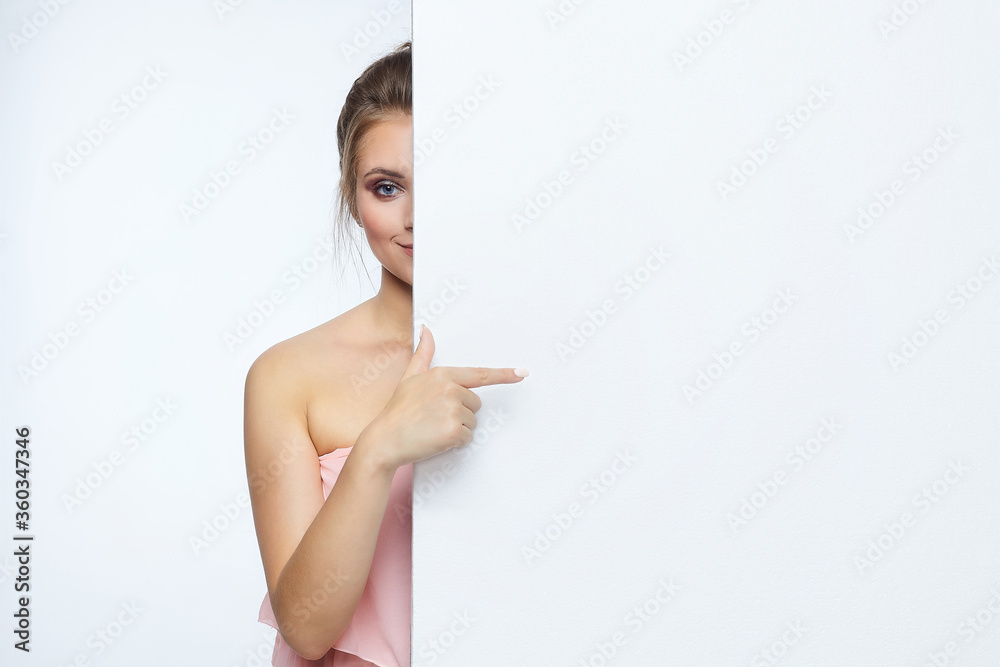 beautiful girl posing in front of the camera. he points to an empty space. advertising concept beautiful girl posing in front of the camera. he points to an empty space. advertising concept