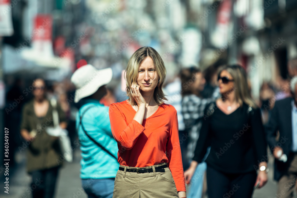 Woman in a red blouse posing on a pedestrian street. Woman in a red blouse posing on a pedestrian street.