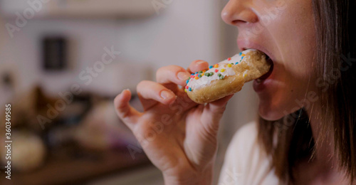 Young woman eats sweet sugar doughnuts - home shooting