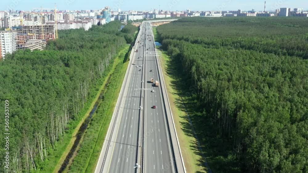 Asphalt ringroad around big city. Speedway through field near forest. Aerial view from copter Asphalt ringroad around big city. Speedway through field near forest. Aerial view from copter
