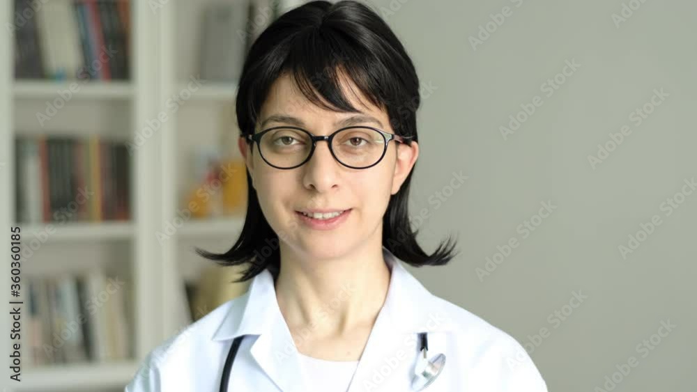 Young adult female doctor talking and smiling. Doctor give advice to patient remote medical consultation. Woman doctor speaking portrait confident and hopeful. Young adult female doctor talking and smiling. Doctor give advice to patient remote medical consultation. Woman doctor speaking portrait confident and hopeful.