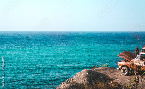 Playa solitaria sin gente, oleaje tranquilo , vista al mar, con un carro estacionado