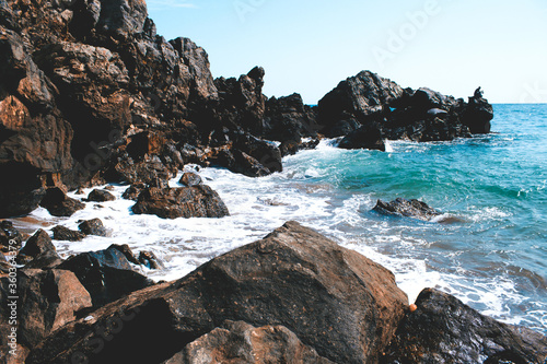 Bild auf Leinwand Olas rompiendo en las rocas en la orilla de la playa