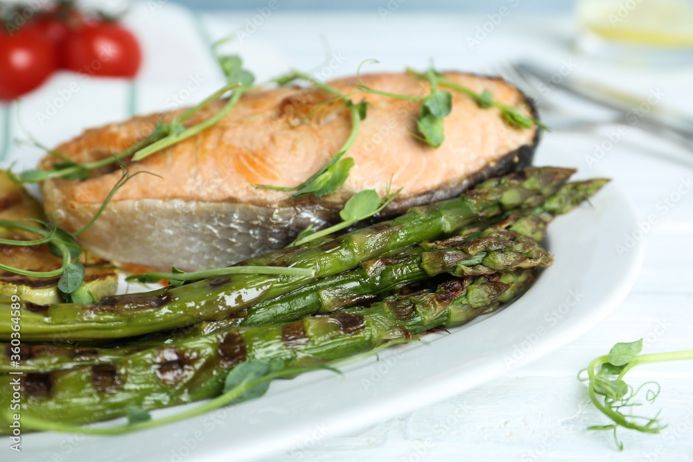 Tasty salmon steak served with grilled asparagus on plate, closeup Tasty salmon steak served with grilled asparagus on plate, closeup