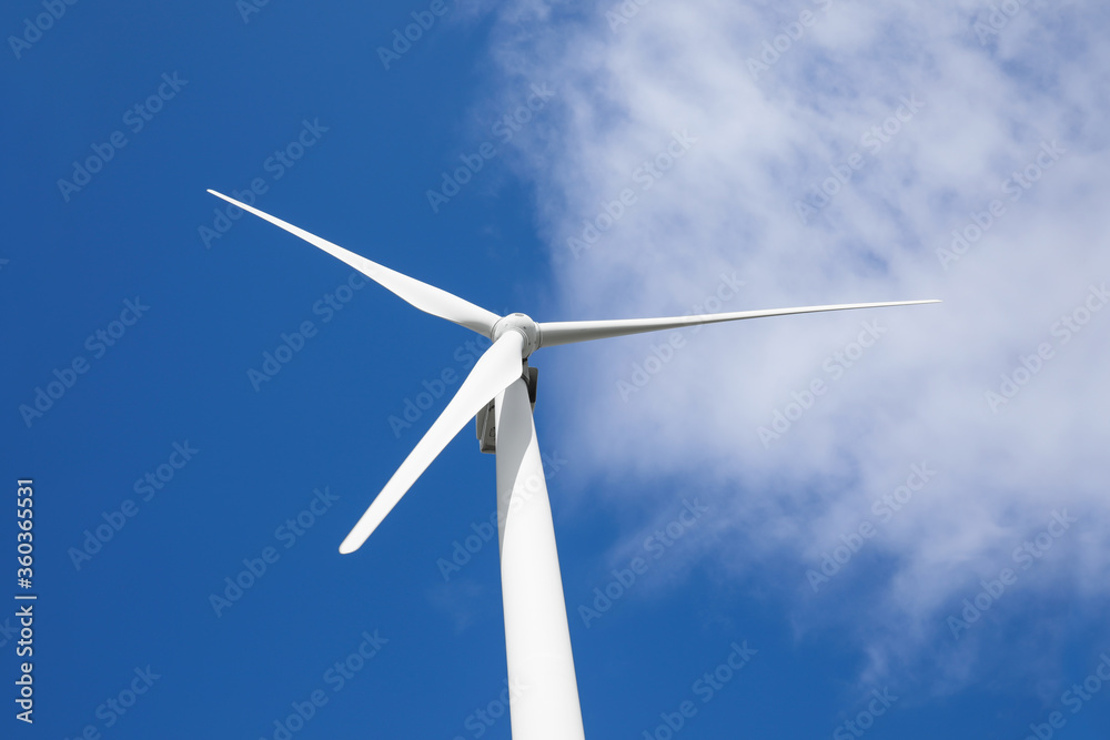 Wind turbine against beautiful blue sky, low angle view. Alternative energy source Wind turbine against beautiful blue sky, low angle view. Alternative energy source
