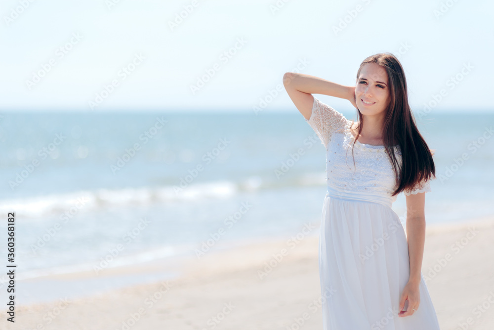Fashion Woman in Long White Dress on the Beach