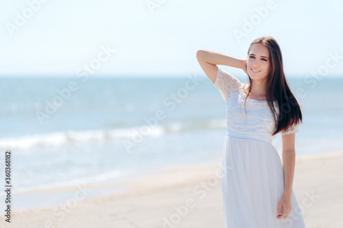 Fashion Woman in Long White Dress on the Beach