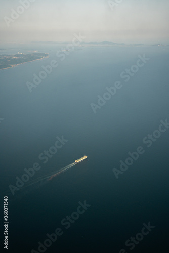 view of the sea from an airplane with large cargoship