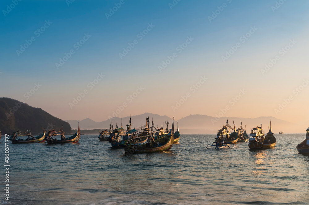 fishing boats on the papuma beach at sunset